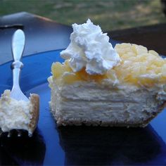 a piece of cake with whipped cream and a fork sitting on a blue plate next to it