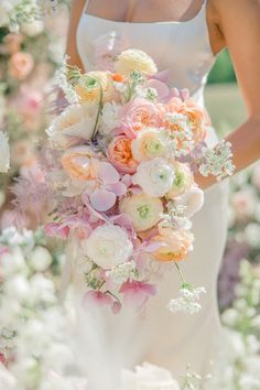 a woman holding a bouquet of flowers in her hand and wearing a white dress with pink accents