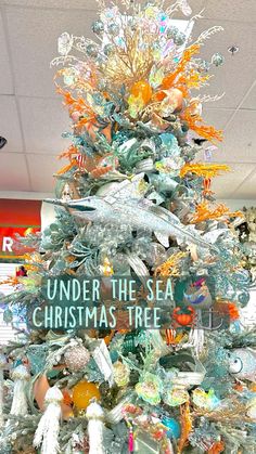 a christmas tree decorated with sea glass and under the sea is a sign that reads, under the sea is a christmas tree