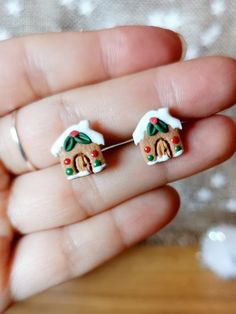 someone is holding their tiny gingerbread house earrings