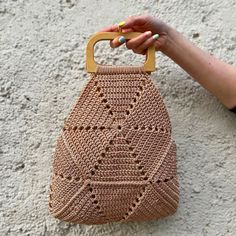 Discover the unique blend of style and sustainability with our handcrafted bohemian handbag, made from high-quality viscose yarn by skilled female artisans. This bag embodies the essence of boho chic, featuring a minimalist design with intricate weaving that perfectly complements any outfit. The smooth wooden handle not only adds a touch of rustic elegance but also ensures comfort and durability, making it ideal for everyday use. Each piece is a testament to the craftsmanship and dedication of women artisans, reflecting their skill and meticulous attention to detail. By choosing this bag, you support sustainable practices and empower women in the art of traditional weaving. Whether you're dressing up for a casual day out or accessorizing for a night on the town, this versatile handbag effo Woven Crochet Top Handle Bag For Daily Use, Everyday Bohemian Hand-knitted Crochet Bag, Crochet Bag With Round Leather Handles In Natural Color, Natural Crochet Bag With Leather Round Handles, Everyday Crochet Bag With Round Handle, Everyday Bohemian Handheld Bucket Bag, Bohemian Natural Hobo Bag With Double Handle, Eco-friendly Crochet Bag With Braided Handles, Everyday Handwoven Crochet Bag With Top Handle