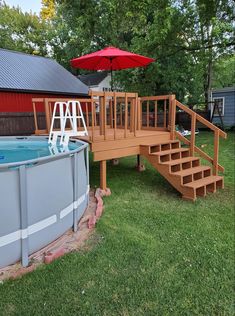 an above ground swimming pool with steps leading up to the deck and umbrella over it