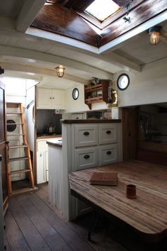 a kitchen with a wooden table in the center and skylights above it on the ceiling