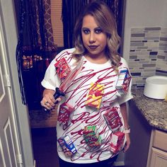 a woman standing in a kitchen with candy on her shirt