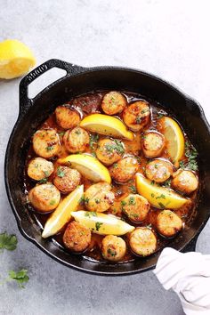 a cast iron skillet filled with potatoes and lemons