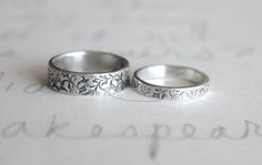 two wedding rings sitting on top of a piece of paper