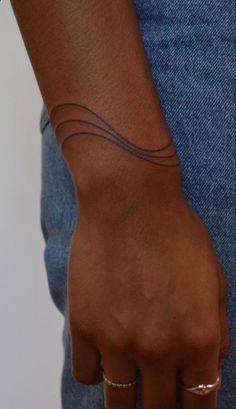 a close up of a person's hand with a tattoo on their left wrist