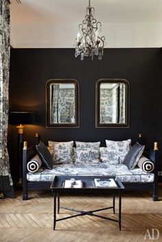 a living room with black walls and white couches