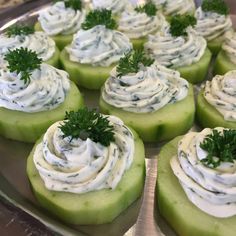 cucumbers with cream cheese and parsley on top are ready to be eaten