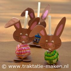 two paper rabbits are standing next to each other with candles in the shape of bunnies