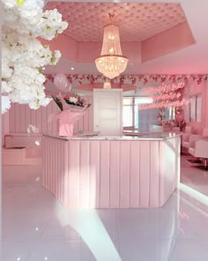 a pink and white room with flowers on the counter, chandelier and couches