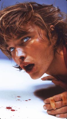 a close up of a person laying on the ground with blood all over his face