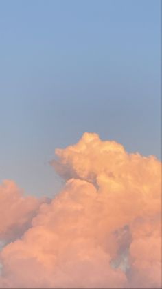 an airplane is flying high in the sky with clouds behind it and a blue sky