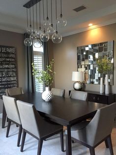 a dining room table and chairs in front of a large mirror with chandelier