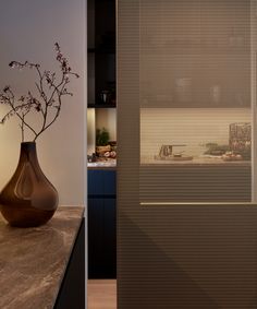 a vase sitting on top of a counter next to a wall