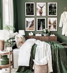 a bedroom with green walls and pictures on the wall above the bed in front of it