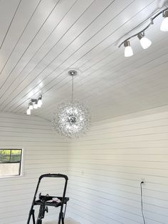 an empty room with white walls and lights on the ceiling is shown in this image