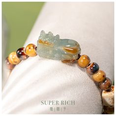 Embrace the fusion of tradition and personal style with our Handmade Jadeite Pixiu Bracelet 天然翡翠貔貅. Carved with care from authentic Type-A Jadeite, each Pixiu charm represents an emblem of abundance and protection. The mystical creature of Pixiu is celebrated in Feng Shui for its power to attract wealth and guard against negativity. This bracelet features an adjustable elastic cord adorned with handmade ceramic beads, making it both stylish and comfortable to wear. Whether as a symbol of self-expression or a thoughtful gift, this bracelet promises to be a cherished addition to any collection. Join our circle of kindness:  with every purchase, we invite you to leave a review. For each one, we'll make a charitable donation. Item Details: *Item No.: SR-LOS-011 *Material: Certified Grade A Jad Crystal Bracelets Diy, Pixiu Bracelet, Mystical Creature, Ceramic Beads Bracelet, Feng Shui Wealth, Lucky Gifts, Ceramic Beads, Crystal Bracelets, Diy Bracelets