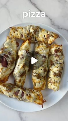 a white plate topped with pizza covered in cheese and toppings on top of a marble counter