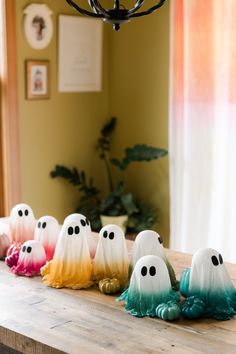 a group of fake ghost sitting on top of a wooden table