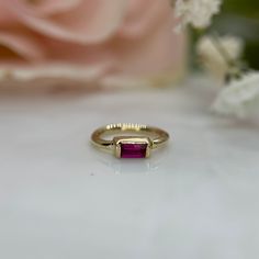 a close up of a ring with a flower in the background