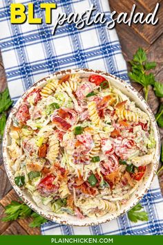 a bowl filled with pasta salad on top of a blue and white checkered table cloth