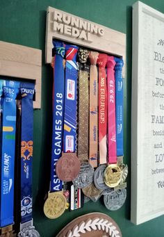 several medals hang on the wall next to a plaque that reads running medal and a baseball mitt