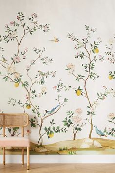 the wallpaper is painted with birds and flowers on it, along with a pink chair