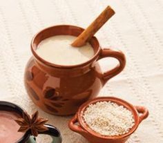 two mugs filled with hot chocolate and cinnamon sitting next to each other on a table