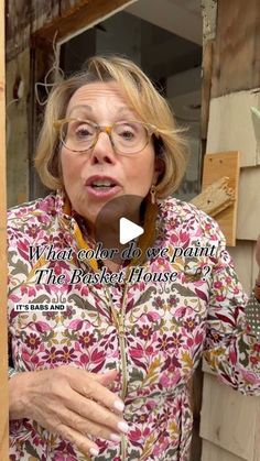 an older woman wearing glasses holding a piece of wood