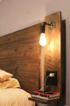 a wooden headboard with a light on it next to a bed