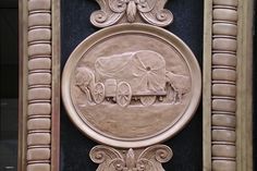 a decorative plaque on the side of a building with an image of a horse drawn carriage