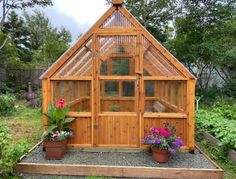 a small wooden greenhouse with potted plants in it