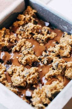 a pan filled with chocolate and oatmeal covered desserts on top of a table