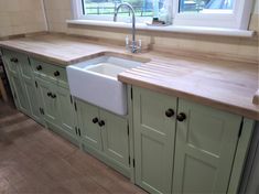 a kitchen with green cabinets and a white sink