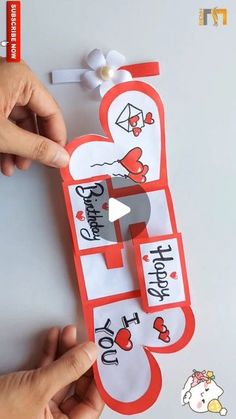 someone is cutting out a valentine's day card with scissors