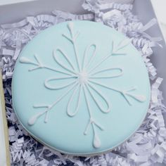 a blue frosted cake with white icing in a box