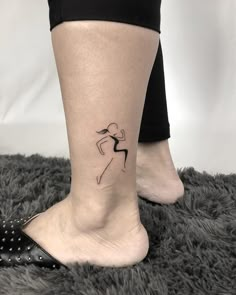 a woman's foot with a small tattoo on it