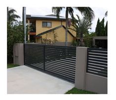 a modern fence is shown in front of a house with palm trees on the other side