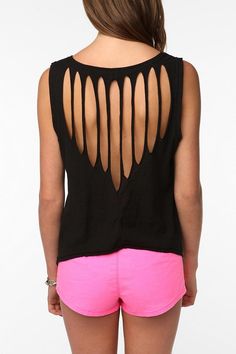 the back of a woman's black top with cutouts on it and pink shorts