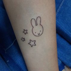 a small rabbit tattoo on the left inner arm, with stars around it's ankles