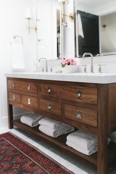 a bathroom with a sink, mirror and rug