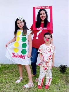 two girls and a boy are dressed up as clowns for the costume contest in front of a white wall