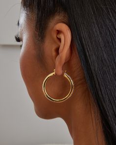 An elegant thin hoop that is set with over 90 pcs of crystals. The earring has a circular design with a slight freeform twist to give the hoop an organic look. All pieces of the jewelry are hand polished and the crystal luster setting exuberates radiant shines. These trendy hoops are made in 18K yellow or white gold plating over sterling silver metal. Closure: Hoop Stamp Approx. Measurement: Outer Length: 1.5 inches Outer Width: 1.4 inches Silver Weight: Approx. 0.12 oz Crystal Quantity: Approx. Circular Design, Gold Plating, Metallic Silver, Gold Earrings, Gold Plate, Hoop Earrings, Plating, White Gold, Sterling Silver