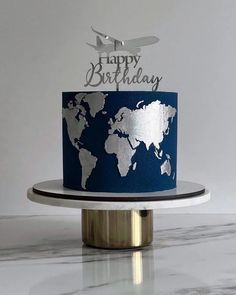 a blue and silver birthday cake with a world map on it