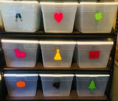 several plastic bins with different shapes and designs on them in a storage area at a school