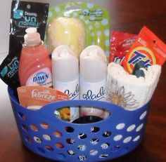 a blue basket filled with baby items on top of a wooden table