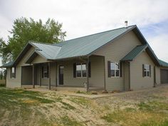 a small house with a metal roof in the grass