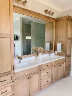 a large bathroom with wooden cabinets and white tile flooring on the walls is pictured in this image