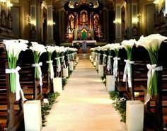 the aisle is decorated with white flowers and greenery